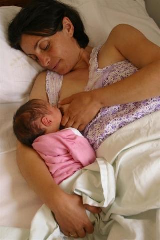 A mother breastfeeds her newborn