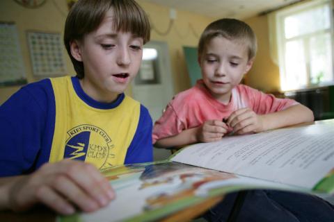 Kids reading together in a library.