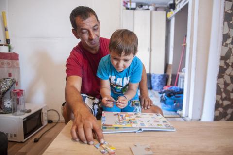 Father reading with his son in their house.