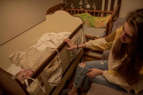 Sister puts her newborn sister to sleep.