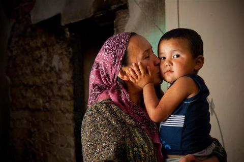 Mother kisses her three-year-old son.