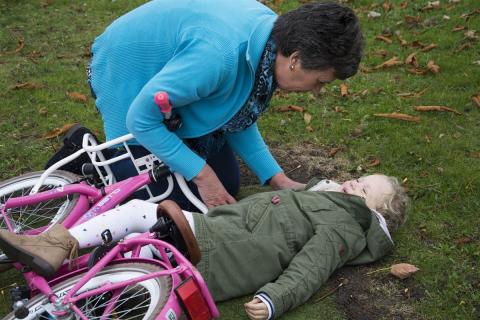  An adult helping a child fallen from a bicycle