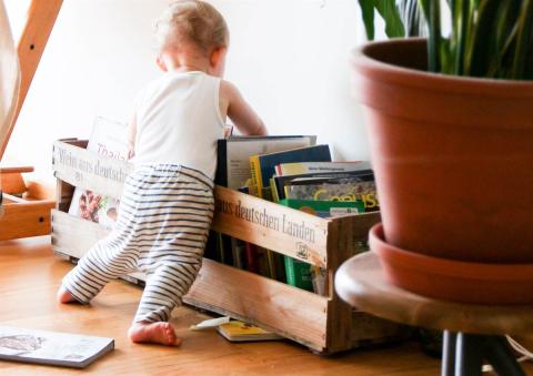 Toddler playing with book at home