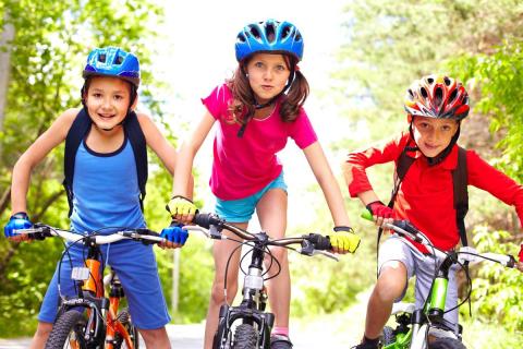 Children on bicycles with protective helmets