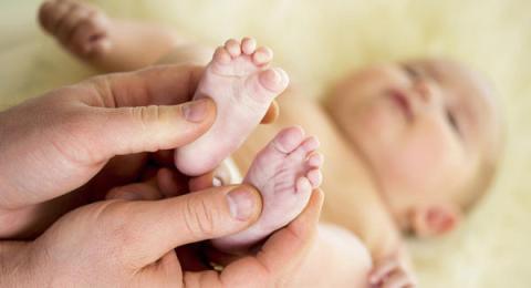 A parent making a feet massage to a baby