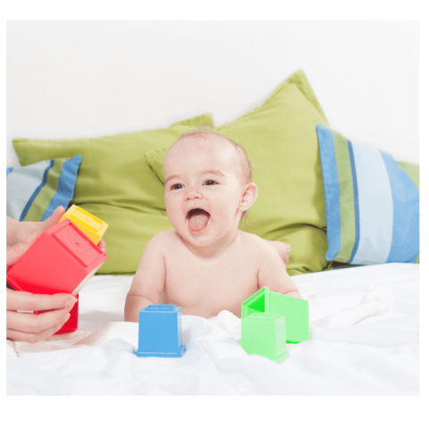 A smiling baby with toys around him or her