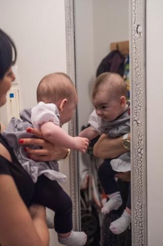 mama i beba pred ogledalom, beba je okrenuta ka ogledalu, komunicira neverbalno sa svojim likom u ogledalu