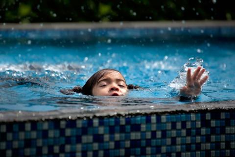 A girl in the pool swallows water and asks for help with her hand