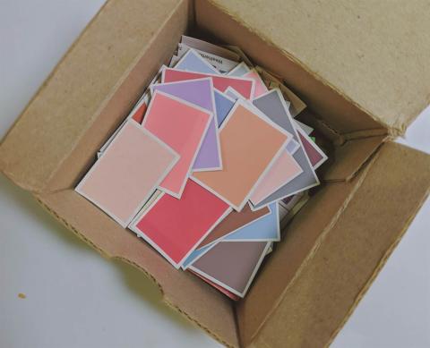 A carboard box with coloured papers inside