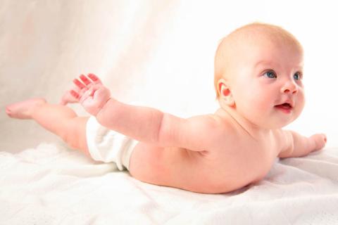 A baby lifting her/his head and hands