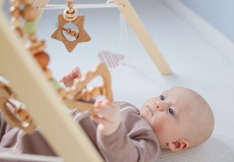 A baby facing different rattles