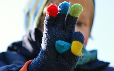 A toddler wearing winter gloves