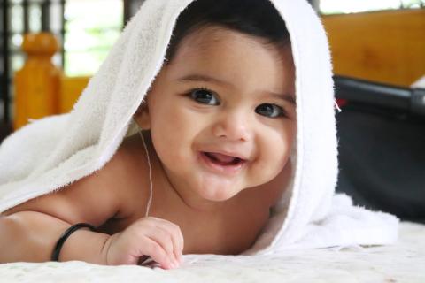 A baby with a towel over his head