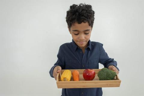 boy holding fresh veggies on a tablet