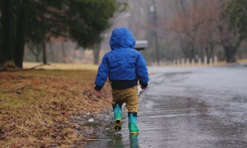 A child walking alone under the rain