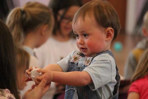 toddler handing a toy to a friend