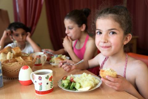 siblings sitting at the table and enjoying lunch
