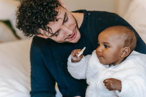 father offering his baby a rice cracker