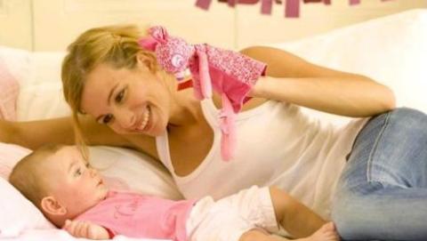 mother holding puppet to baby's face