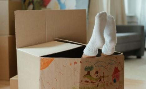 child's feet sticking out of a cardboard box
