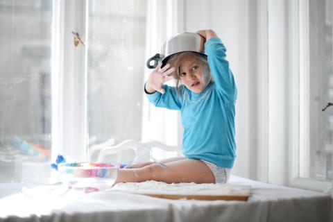 toddler wearing saucepan as a hat