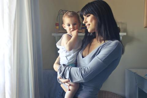 Mother holding baby, talking about the objects surrounding them