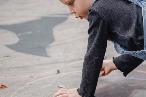 girl drawing with chalk on the street