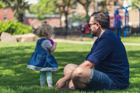 father with daughter sitting in the park