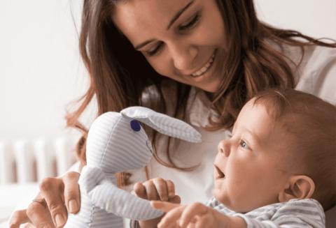 mother showing her baby a stuffed rabbit