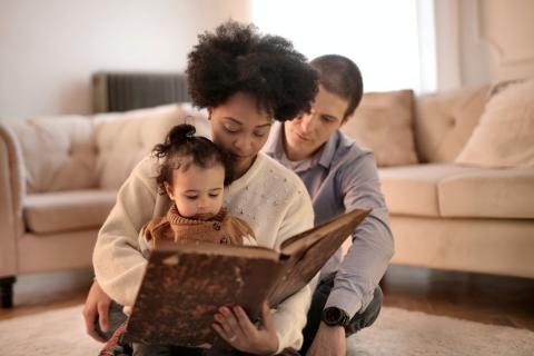 parents reading to their daughter 