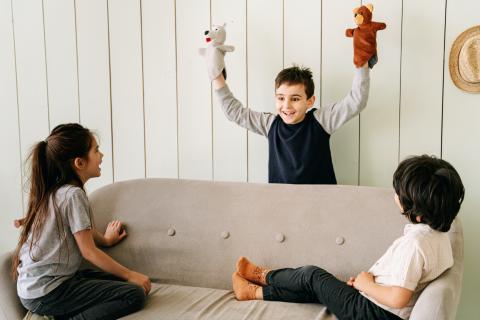 child acting out a play with puppets