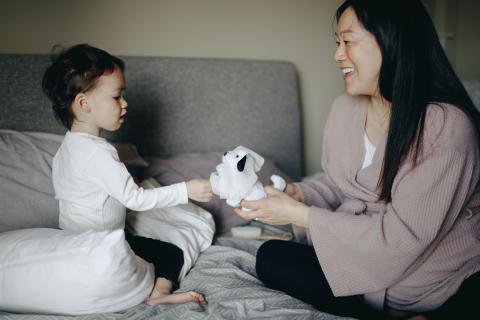 mother holding toy out for child