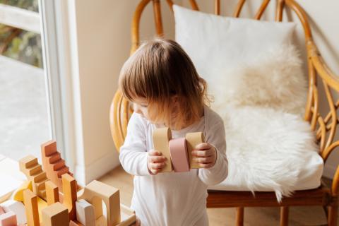 toddler picking up building blocks