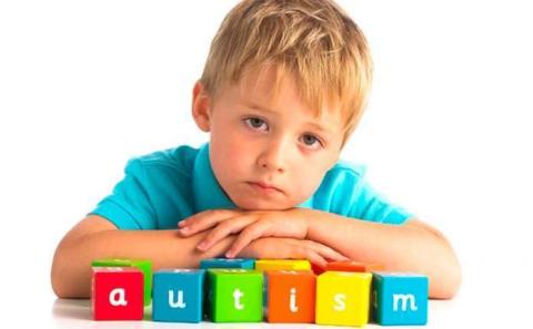 Хлопчик з кубиками на яких написано autism