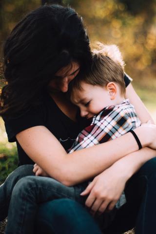 Stressed child sits in their mother's lap