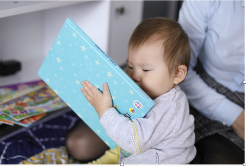 Unicefkg/Малыш держит книгу