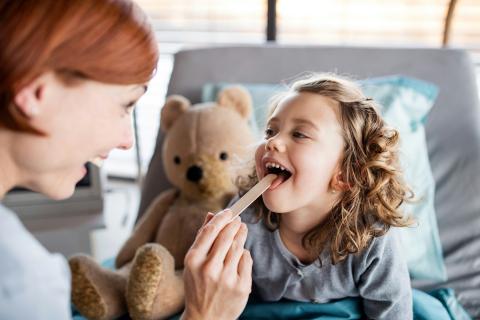 Doctor checking child's mouth