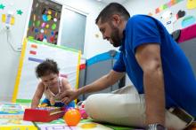 A father is playing the musical instrument with the child