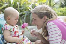 A mother showing the flower to her baby