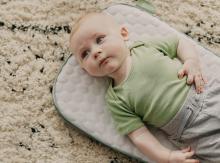 A child is laying on her or his back and focusing her or his sight on something