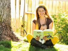 A mother looking at the book with her baby