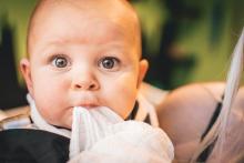 A baby with a tissue in her or his mouth
