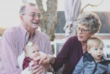 Grandmother and grandfather carrying two babies