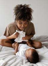 Mother changing her baby's diaper